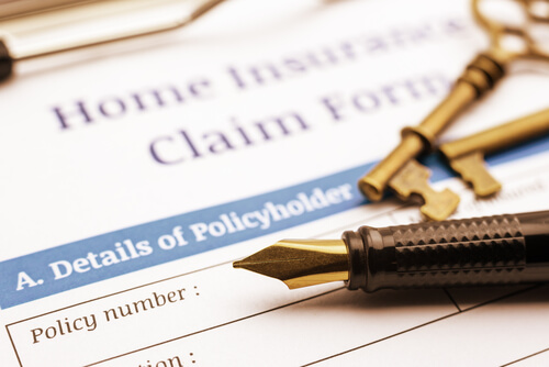 A pen and key place above the insurance claim form